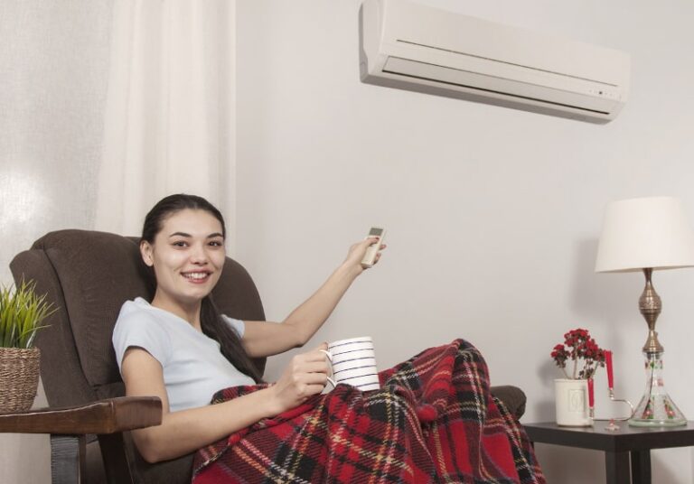 woman pointing remote to ductless hvac system