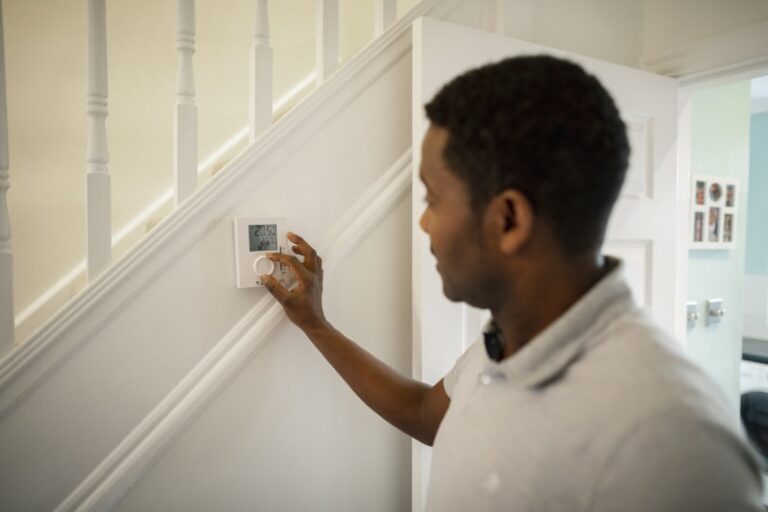 man setting thermostat