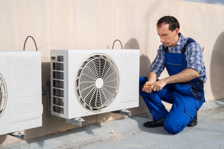 man works on air conditioner unit
